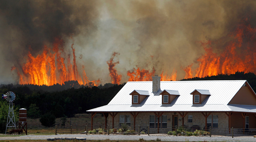 Wildfire threatens a house